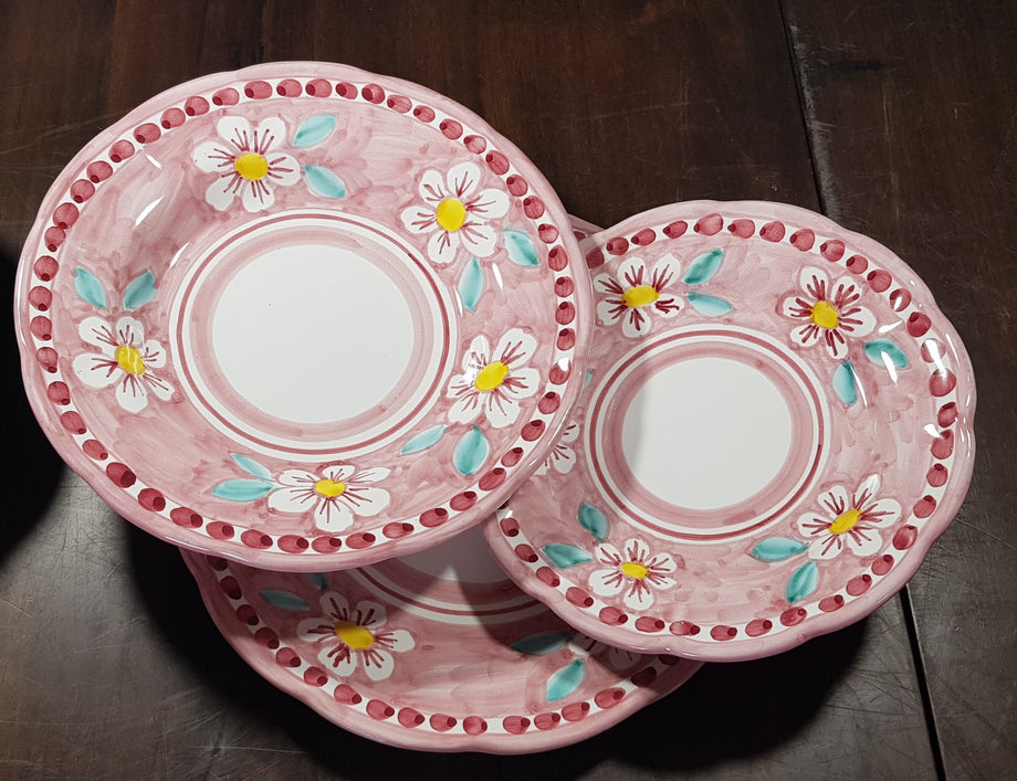 Tris di piatti linea fiori fondo rosa. Ceramica di vietri dipinta
